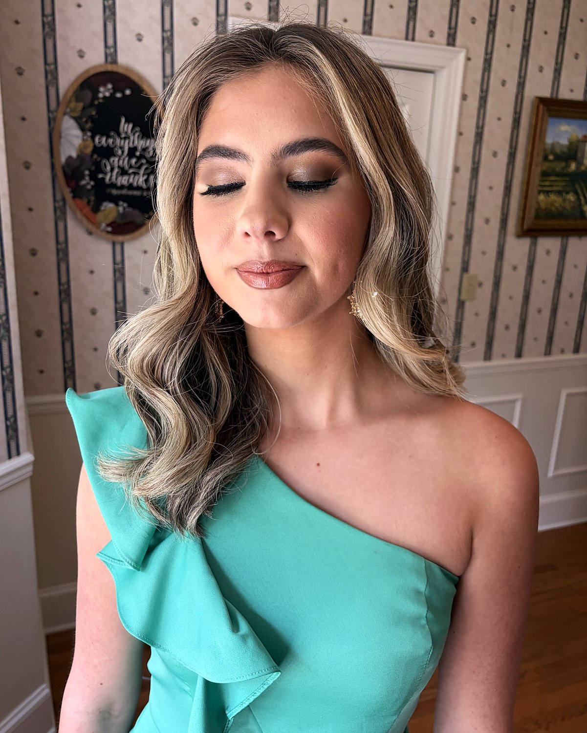Brown shimmer eyeshadow, lashes and a glossy nude lip with soft blonde-highlighted waves