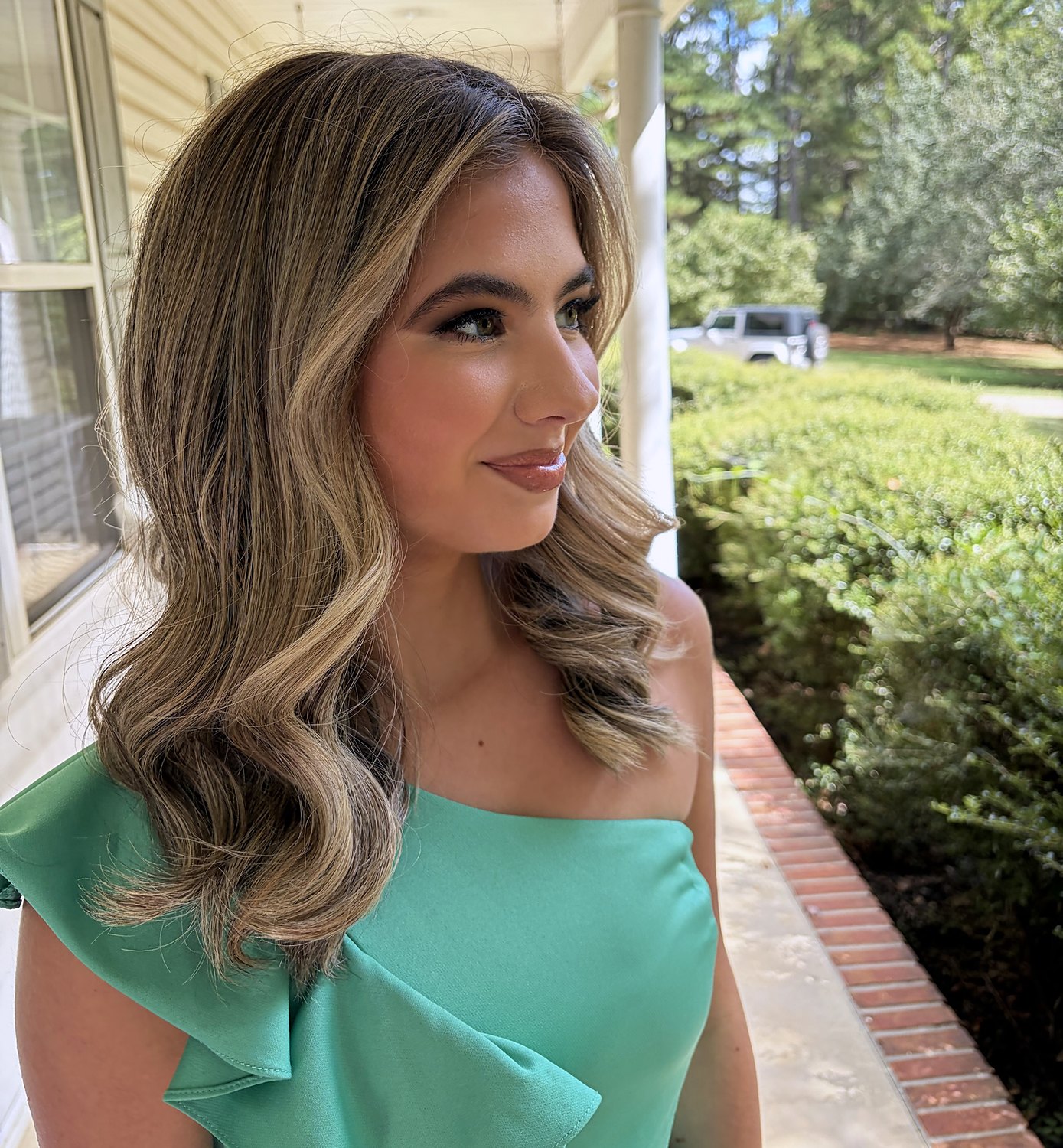 Profile of long soft waves with caramel and blonde highlights