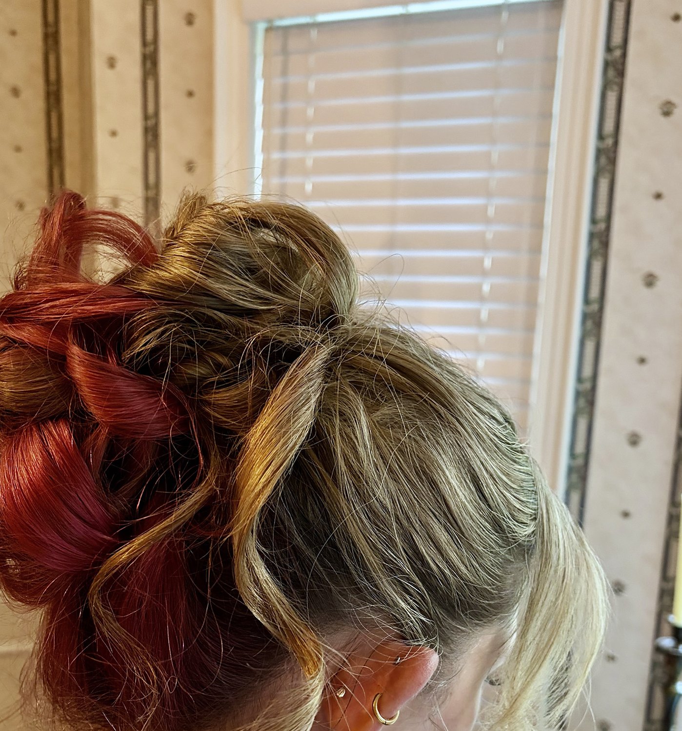 Side view of a high loose updo with red and blonde tones