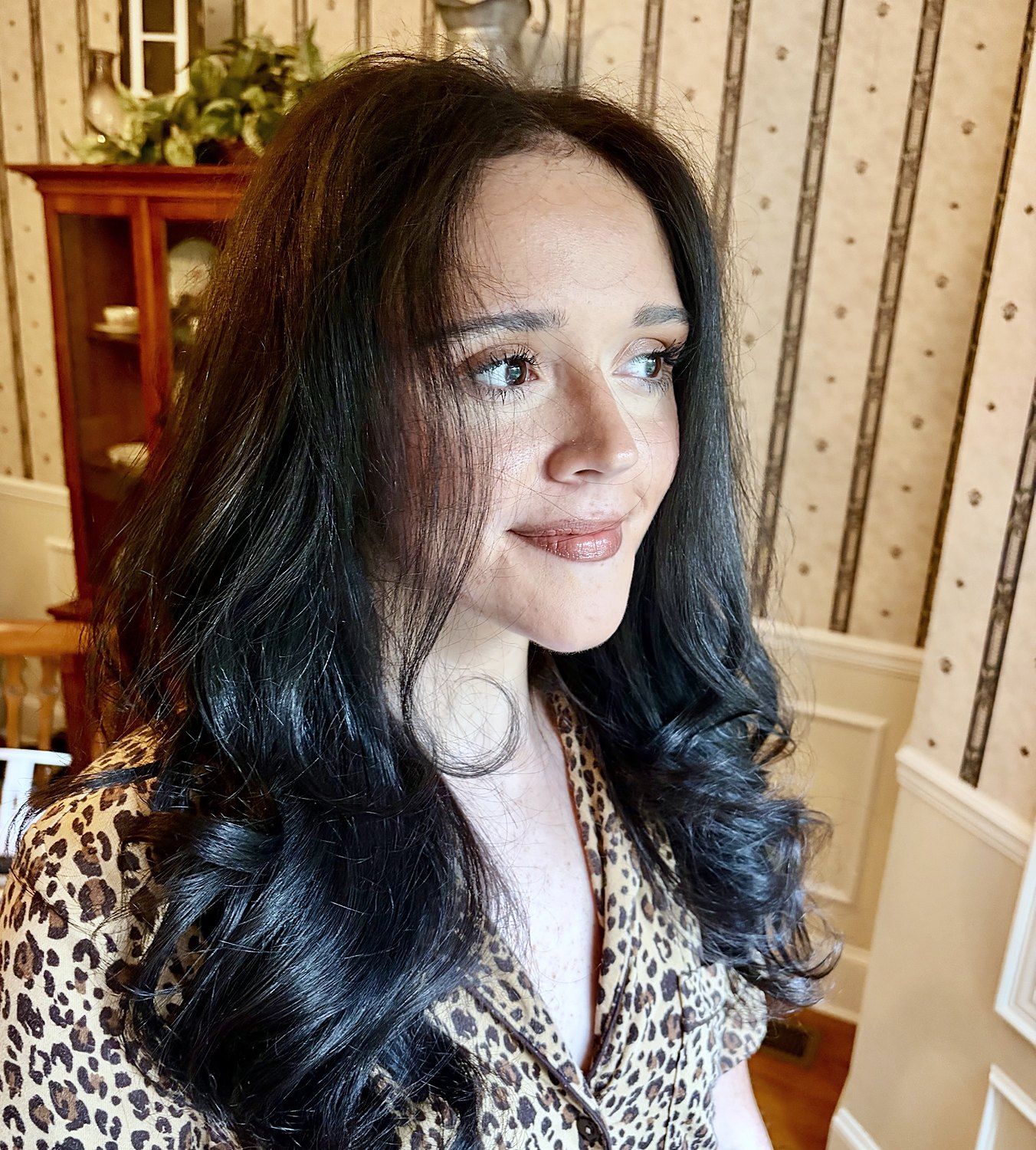 Glossy black hair in big bouncy curls with natural makeup